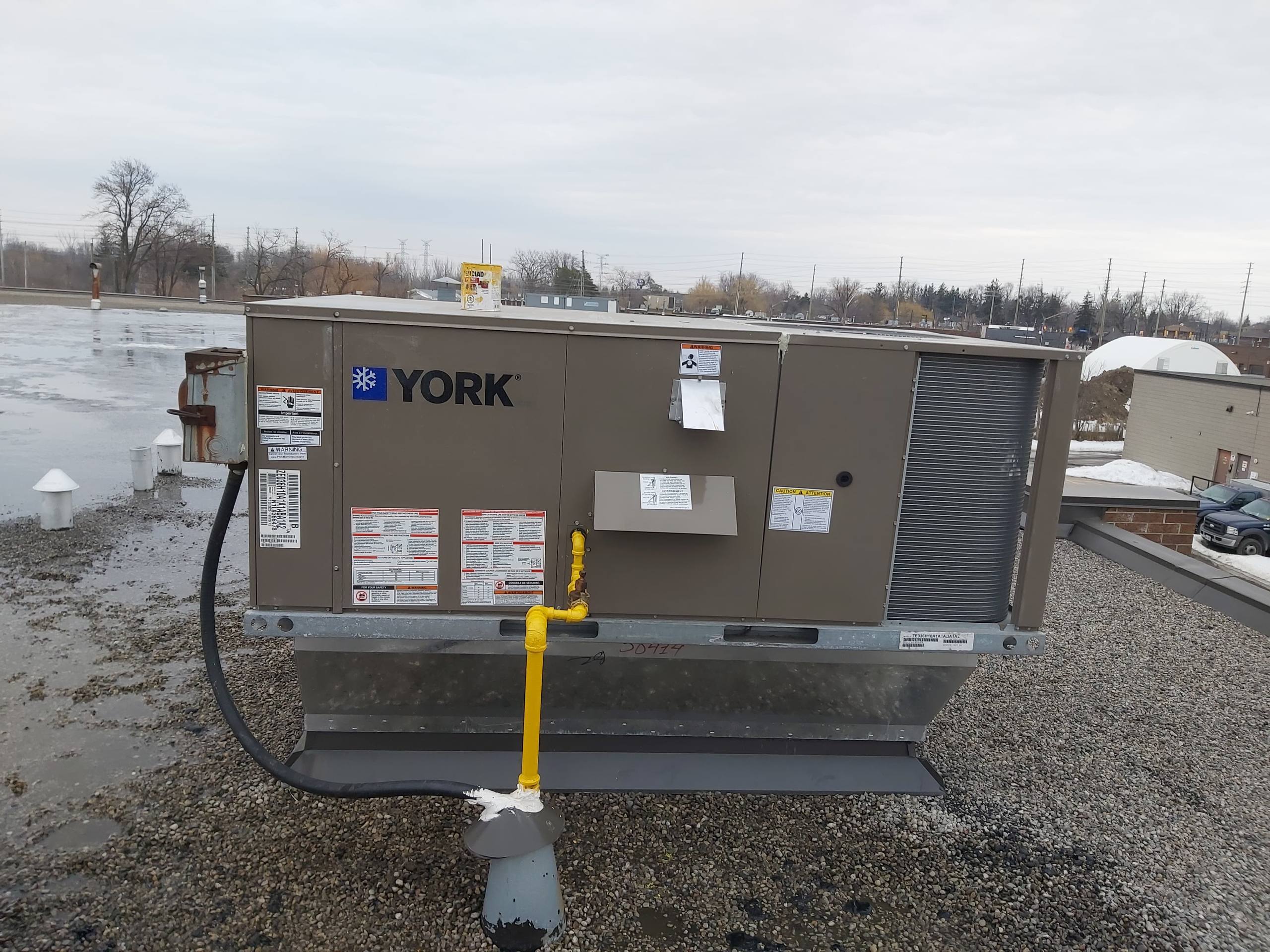 Commercial rooftop unit service in winter conditions.