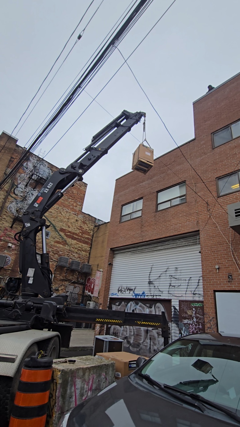 Olu HVAC craning a commercial rooftop unit into place in the GTA